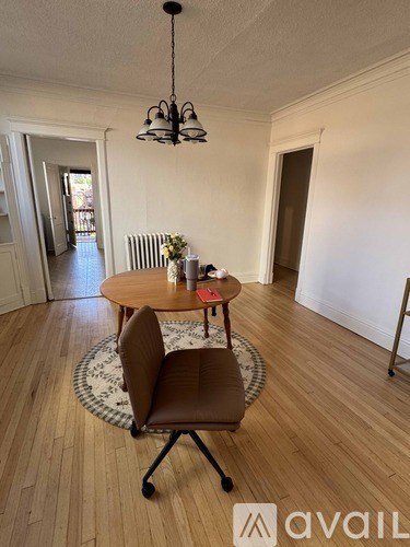 A room with a table, chairs, and a fireplace.