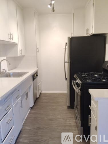 A kitchen with white cabinets and a black stove top.