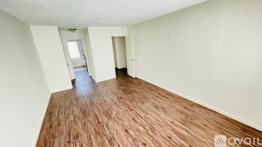 A room with wooden flooring and white walls.