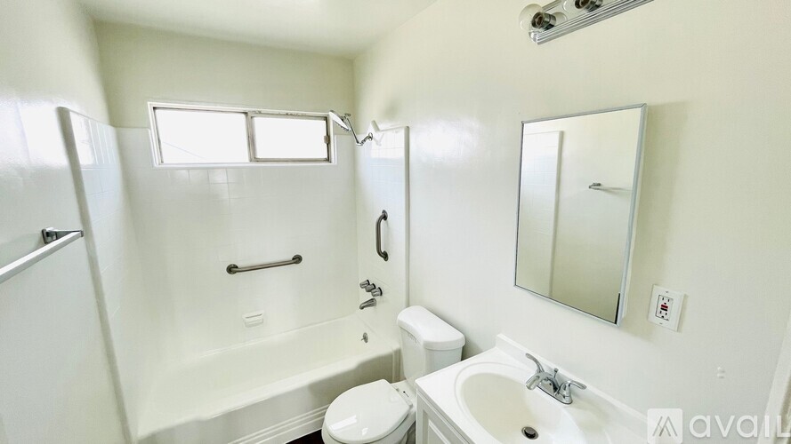 A white bathroom with a toilet, sink, and bathtub.