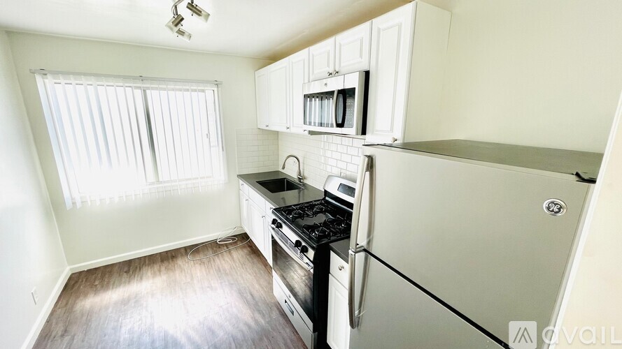 A kitchen with a stove top oven and a refrigerator.