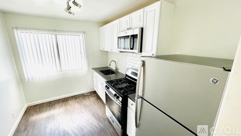 A kitchen with a stove top oven and a refrigerator.
