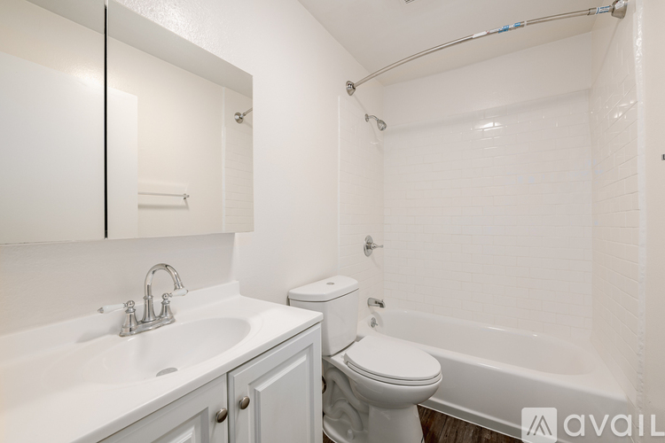 A white bathroom with a toilet, sink, and bathtub.