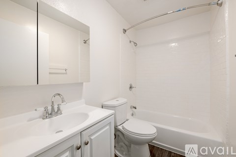 A white bathroom with a toilet, sink, and bathtub.