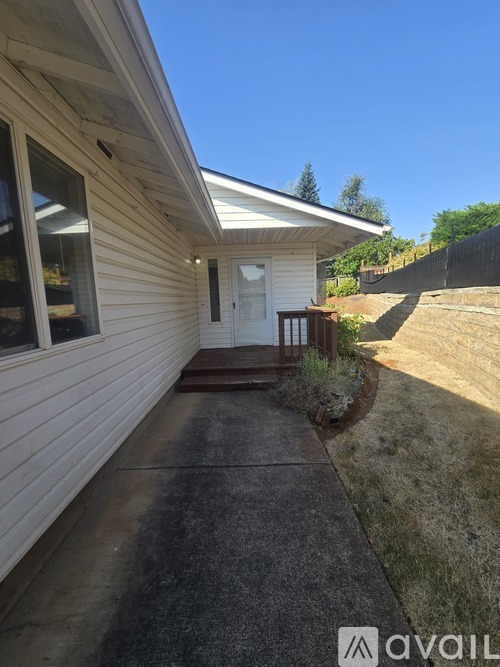 A house with a white door and windows is available for rent.
