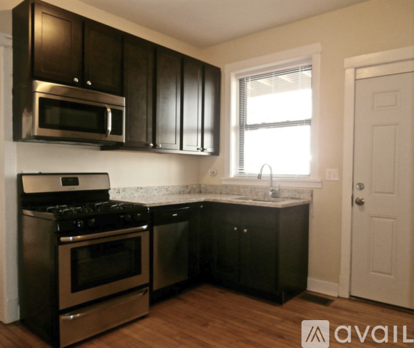 A kitchen with black cabinets and stainless steel appliances.