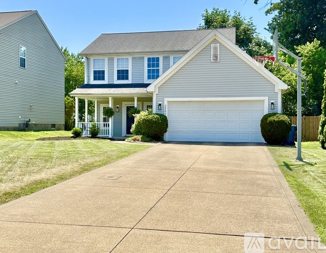 A two-story house with a garage and a driveway.