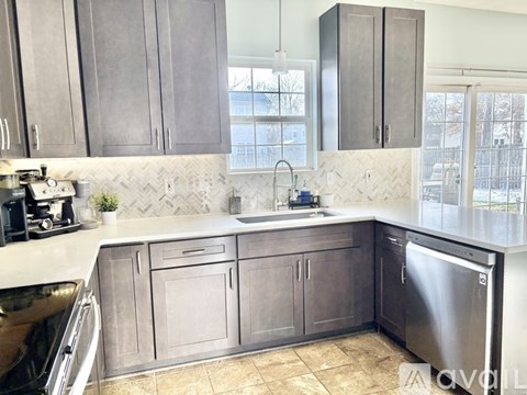 A kitchen with dark wood cabinets and a white countertop.