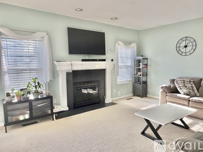 A living room with a fireplace, television, and a couch.