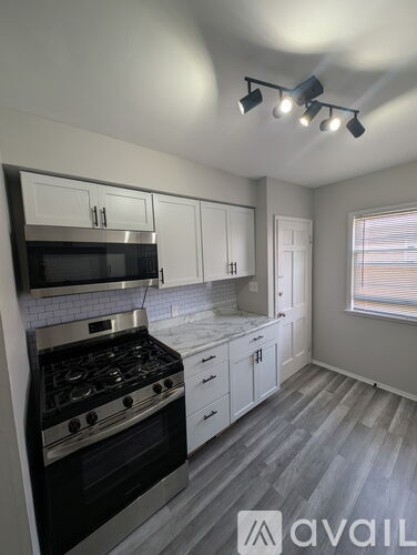A kitchen with a stove, microwave, and cabinets.