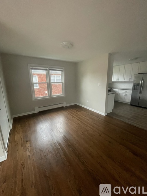 A room with wooden flooring and a window.