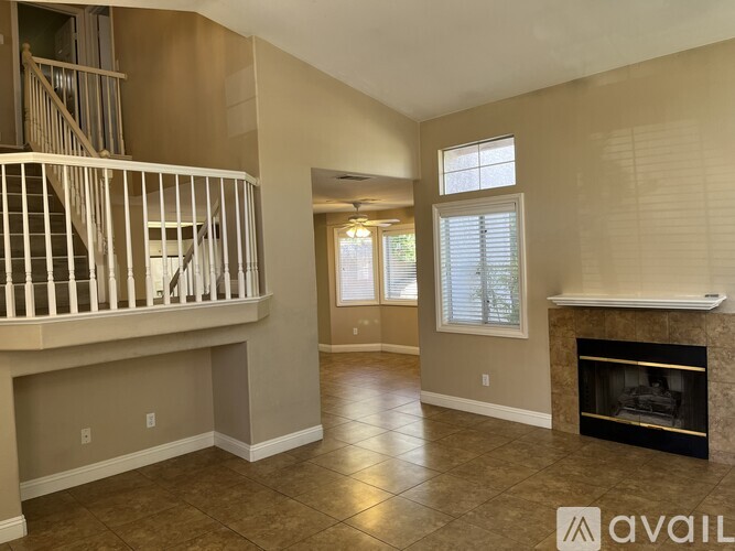 A living room with a fireplace and a staircase.