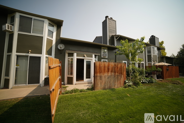 A house with a brown fence and a green lawn.