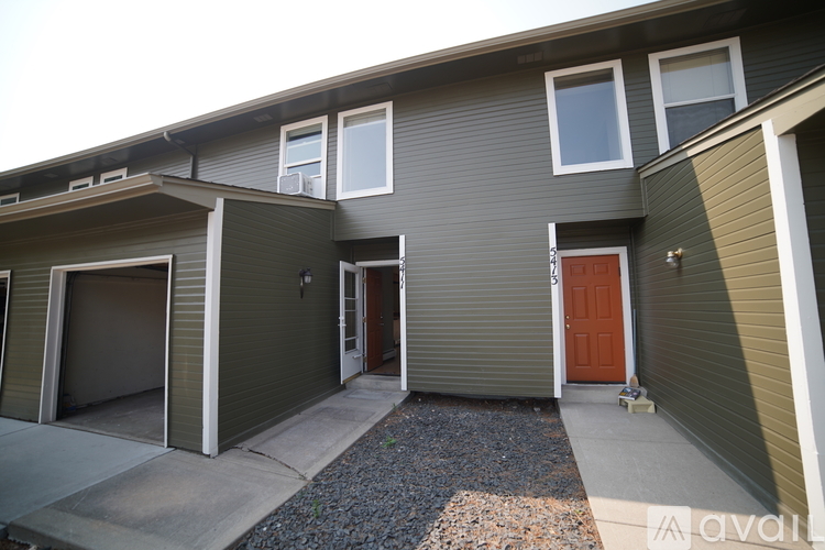 A house with a brown door and a grey wall.