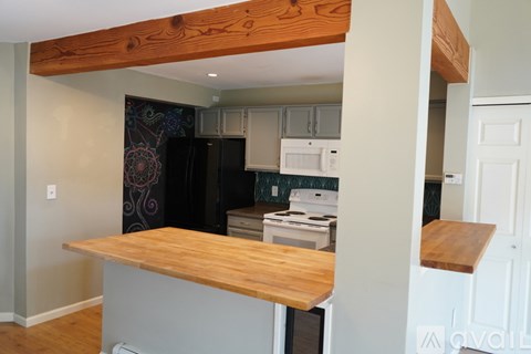 A kitchen with a white fridge and stove top oven.