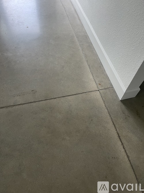 A concrete floor with a white wall on the side.
