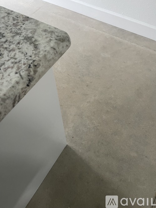 A marble countertop with a white base and a grey floor.