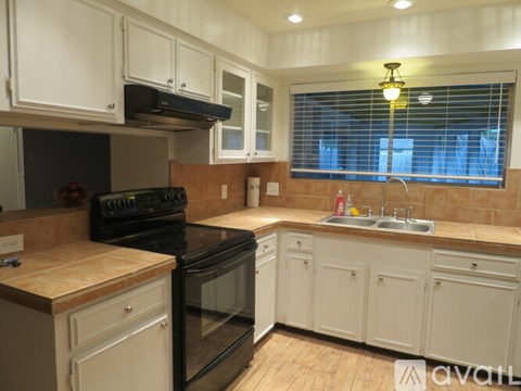 A kitchen with white cabinets and a black oven.