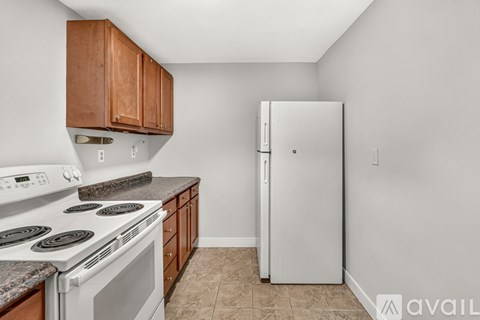 A kitchen with a white stove top oven and a white refrigerator.