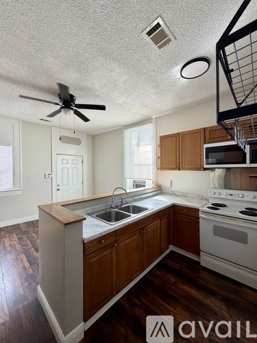 A kitchen with wooden cabinets and a white stove top oven.