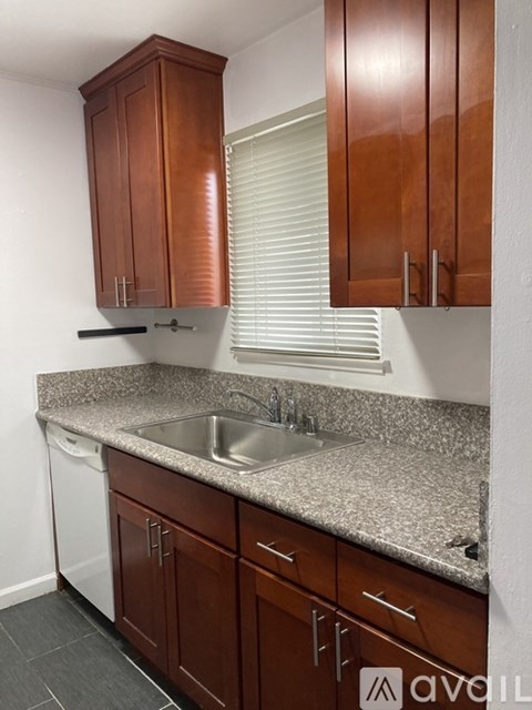 A kitchen with brown cabinets and a granite countertop.