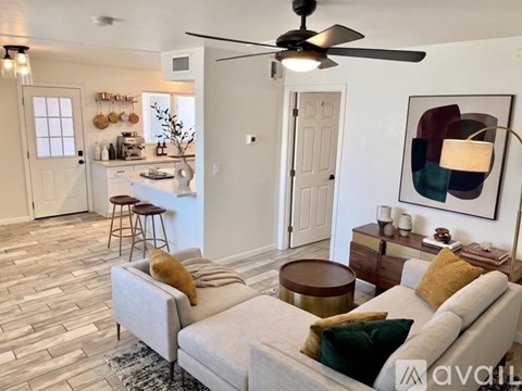 A living room with a grey couch and a ceiling fan.