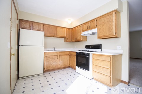 A kitchen with wooden cabinets and a white refrigerator.