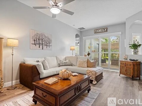 A living room with a brown coffee table and a white couch.