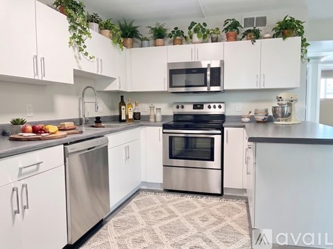 A kitchen with white cabinets and a black countertop.