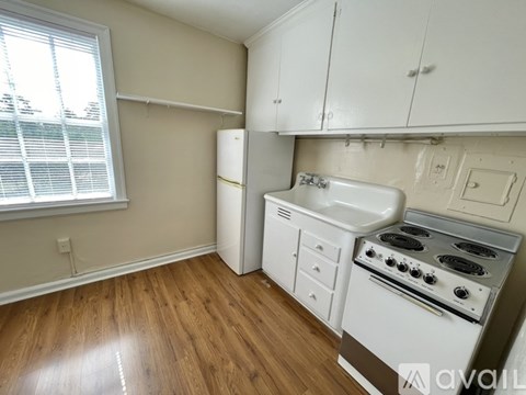 A kitchen with a white stove and cabinets.