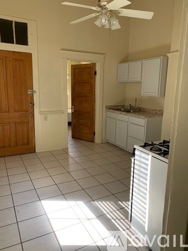 A kitchen with a white stove and a fan.
