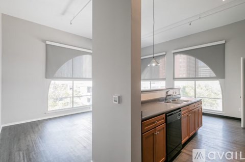 A modern kitchen with wooden cabinets and a large window.