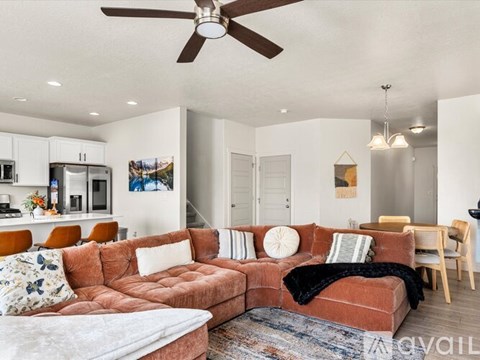 A living room with a red couch and a ceiling fan.