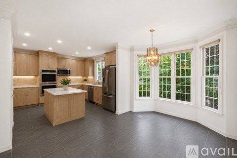 A modern kitchen with wooden cabinets and a central island.