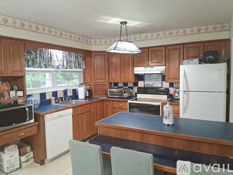 A kitchen with wooden cabinets and a white refrigerator.