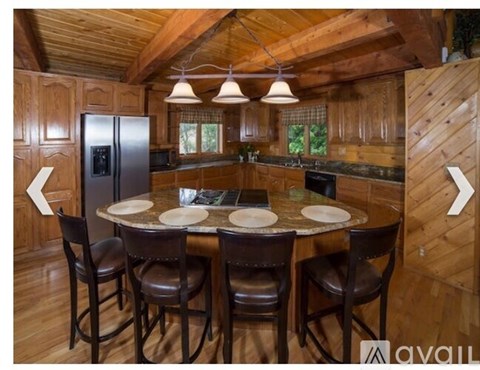 A wooden kitchen with a table and chairs.