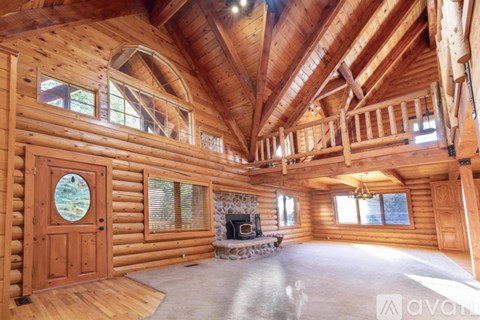 A bedroom with a bed, wooden walls, and a window.