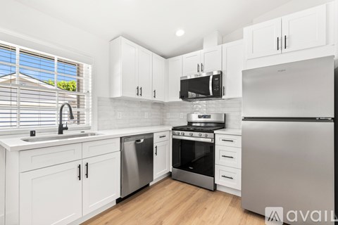 A kitchen with white cabinets and stainless steel appliances.