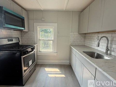 A kitchen with a black stove top oven and white cabinets.