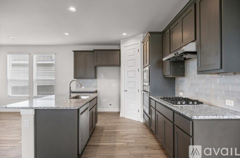 A modern kitchen with dark wood cabinets and a marble countertop.