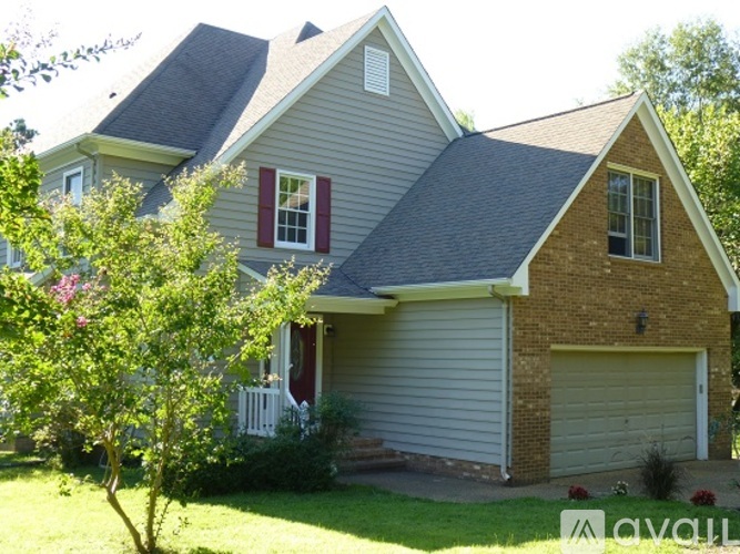 A house with a grey roof and a red window.