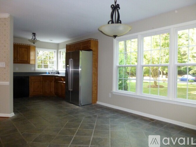 A kitchen with a refrigerator and a dining table.