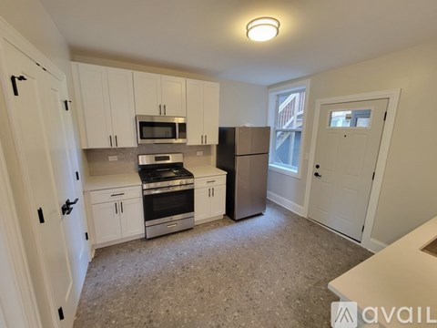 A kitchen with white cabinets and stainless steel appliances.