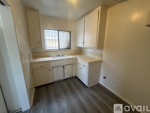 A kitchen with white cabinets and a window.