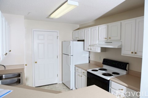 A kitchen with white cabinets and appliances is available for rent.