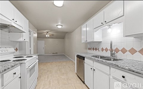 A kitchen with white cabinets and a marble countertop.