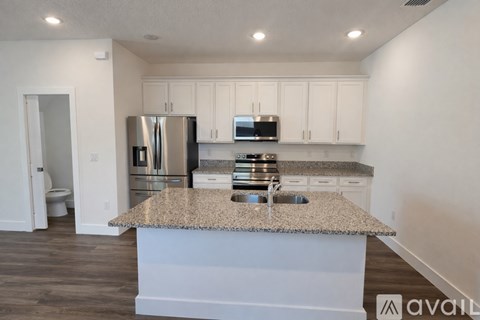 A kitchen with a granite countertop and stainless steel appliances.