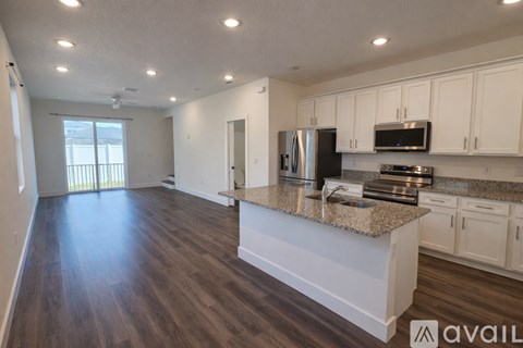 A kitchen with a granite countertop and white cabinets.
