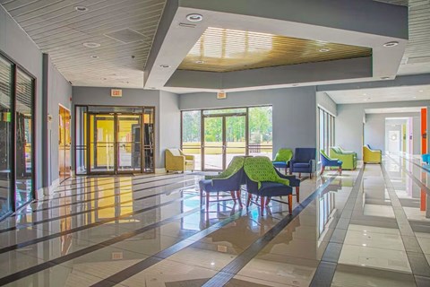 A spacious lobby with a reflective floor and a ceiling with wooden slats.
