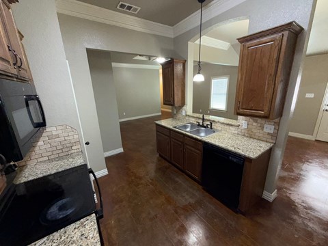 A kitchen with brown cabinets and a black stove top oven.